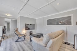 Living area with light wood-style floors, recessed lighting, and coffered ceiling - 