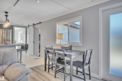 Dining area with healthy amount of natural light, a barn door, recessed lighting, and light wood-style flooring - 