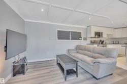 Living room with light wood-type flooring and recessed lighting - 