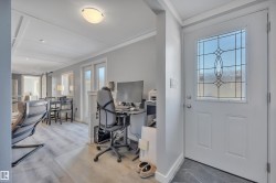 Office area featuring a barn door, ornamental molding, and light wood-style floors - 