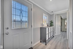 Foyer entrance featuring crown molding and light wood-style flooring - 