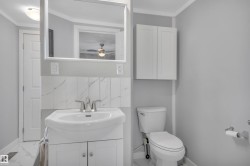 Bathroom with vanity, backsplash, marble look tile flooring, ornamental molding, and a ceiling fan - 