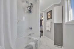 Bathroom featuring shower / tub combo with curtain, connected bathroom, marble finish flooring, a ceiling fan, and crown molding - 