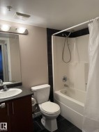 Full bath featuring dark tile patterned flooring, vanity, and shower / tub combo - 