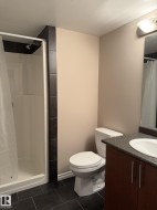 Bathroom featuring a shower stall, vanity, and dark tile patterned flooring - 