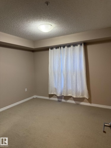 Unfurnished room with a textured ceiling, carpet flooring, and a pendent fire sprinkler - 303 10118 106 Avenue, Edmonton, AB - Indoor Photo Showing Other Room