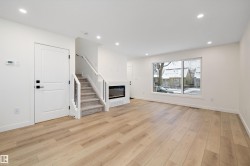 Unfurnished living room with recessed lighting, a glass covered fireplace, light wood finished floors, and stairs - 