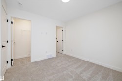 Unfurnished bedroom featuring light colored carpet and a walk in closet - 