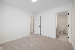 Unfurnished bedroom with light carpet and light tile patterned floors - 