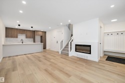 Unfurnished living room featuring recessed lighting, a glass covered fireplace, light wood-type flooring, and stairway - 