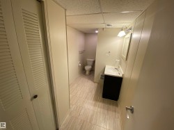 Bathroom featuring a paneled ceiling, vanity, and a closet - 