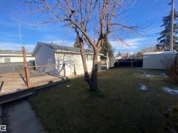 View of yard with a wooden deck and an outbuilding - 