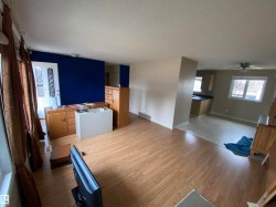 Unfurnished living room with a textured ceiling, wood finished floors, and ceiling fan - 