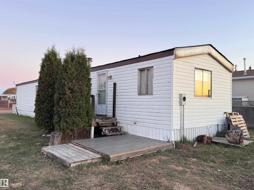 Back of house at dusk featuring a yard and entry steps - 4748 50 St., Vimy, AB - Outdoor With Exterior