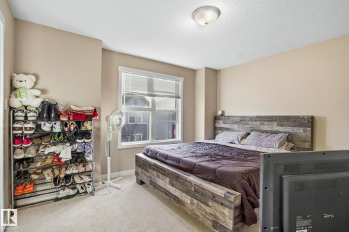Bedroom with carpet flooring and a textured ceiling - 30 6075 Schonsee Way, Edmonton, AB - Indoor Photo Showing Bedroom