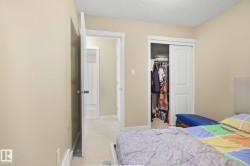 Bedroom with light colored carpet, a textured ceiling, and a closet - 