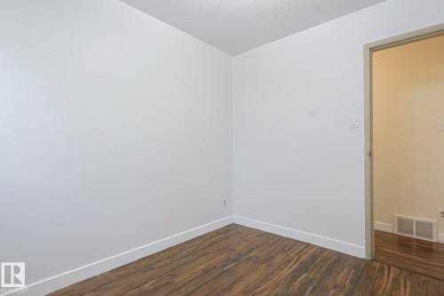 Empty room with dark wood-style floors and a textured ceiling - 51 Belmead Gardens, Edmonton, AB - Indoor Photo Showing Other Room
