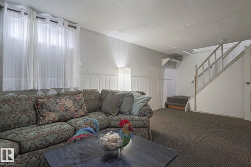 Living area with stairway, carpet flooring, wainscoting, and a textured wall - 51 Belmead Gardens, Edmonton, AB - Indoor Photo Showing Other Room