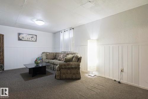 Living room with wainscoting, carpet flooring, a textured ceiling, and a textured wall - 51 Belmead Gardens, Edmonton, AB - Indoor