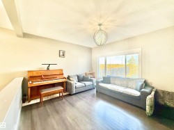 Living room featuring wood finished floors, a textured ceiling, and a chandelier - 