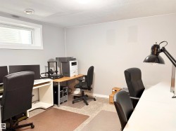 Home office with light carpet and a textured ceiling - 