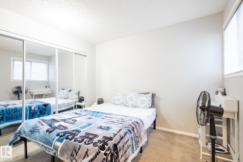 Bedroom featuring light carpet, a closet, and a textured ceiling - 3530 42 Street, Edmonton, AB - Indoor Photo Showing Bedroom