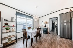 Dining room featuring dark wood-style flooring, crown molding, a chandelier, and vaulted ceiling - 