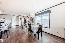 Dining area with crown molding, light wood-type flooring, a chandelier, and a water view - 