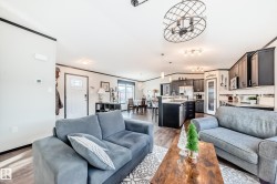 Living area with crown molding, wood finished floors, and a chandelier - 