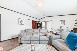 Living area featuring an office area, wood finished floors, vaulted ceiling, and ornamental molding - 