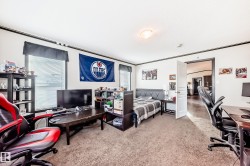 Living room with vaulted ceiling, a barn door, wood finished floors, and an office area - 