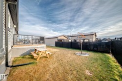 Laundry room with a textured ceiling, light wood-type flooring, and stacked washing machine and dryer - 