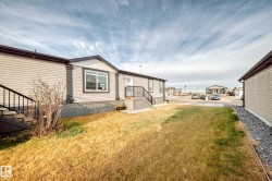 Back of property with a fenced backyard and a wooden deck - 