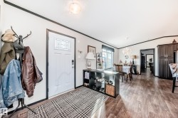 Foyer featuring vaulted ceiling, light wood-style floors, and crown molding - 