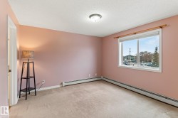 Unfurnished room with light carpet, a textured ceiling, and baseboard heating - 