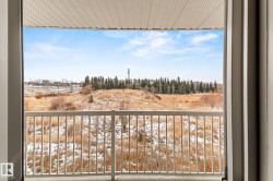 Snow covered back of property featuring view of wooded area - 
