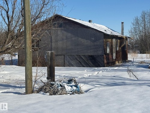 The property features a wooden exterior with some areas boarded - 4904 51 Avenue, Opal, AB - Outdoor