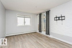 Unfurnished room featuring light wood-style flooring and a baseboard radiator - 