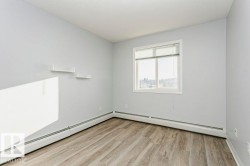 Unfurnished room featuring a baseboard heating unit and light wood-type flooring - 