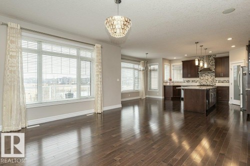Unfurnished living room with a chandelier, a textured ceiling, dark wood-style floors, and recessed lighting - 3198 Winspear Crescent Sw, Edmonton, AB - Indoor Photo Showing Other Room