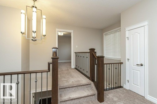 Hallway with carpet flooring, a textured ceiling, an upstairs landing, and a chandelier - 3198 Winspear Crescent Sw, Edmonton, AB - Indoor Photo Showing Other Room