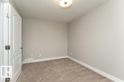 Spare room featuring light colored carpet and a textured ceiling - 