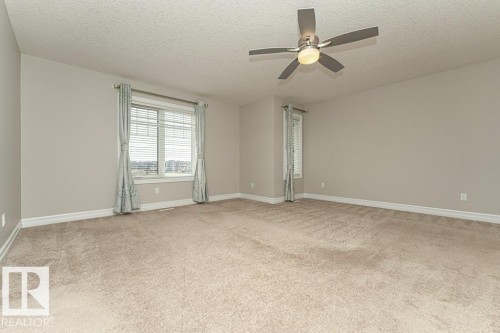 Unfurnished room with a textured ceiling, light colored carpet, and ceiling fan - 3198 Winspear Crescent Sw, Edmonton, AB - Indoor Photo Showing Other Room