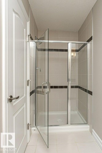 Bathroom with a shower stall, light tile patterned floors, and a textured ceiling - 3198 Winspear Crescent Sw, Edmonton, AB - Indoor Photo Showing Bathroom