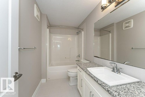 Bathroom with vanity, a textured ceiling,  shower combination, and light tile patterned flooring - 3198 Winspear Crescent Sw, Edmonton, AB - Indoor Photo Showing Bathroom
