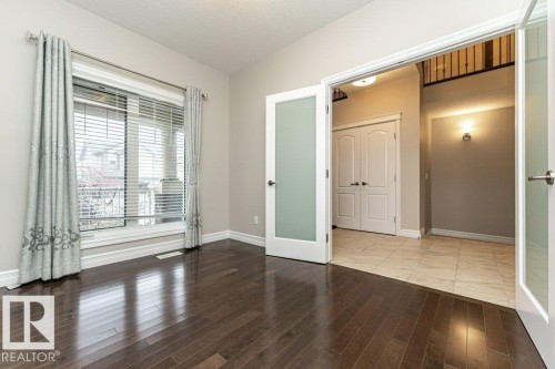 Unfurnished bedroom with hardwood / wood-style floors, french doors, a textured ceiling, and a closet - 3198 Winspear Crescent Sw, Edmonton, AB - Indoor Photo Showing Other Room