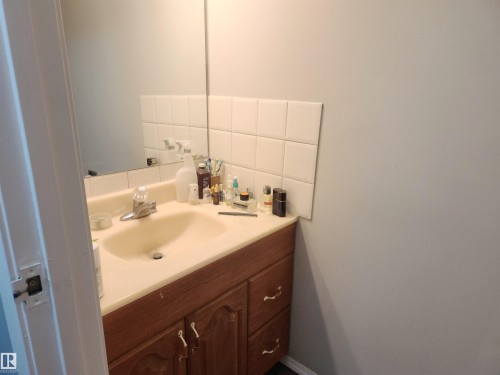 Half bath with vanity and tasteful backsplash - 162 Abbottsfield Road, Edmonton, AB - Indoor Photo Showing Bathroom