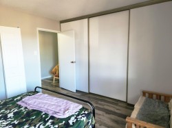 Bedroom with wood finished floors, a closet, and a textured ceiling - 