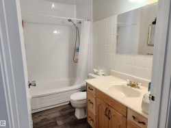 Bathroom featuring shower / bath combination with curtain, tile walls, vanity, and dark wood finished floors - 