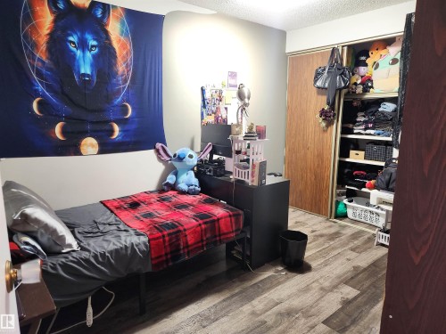 Bedroom featuring wood finished floors, a textured ceiling, and a closet - 162 Abbottsfield Road, Edmonton, AB - Indoor Photo Showing Bedroom